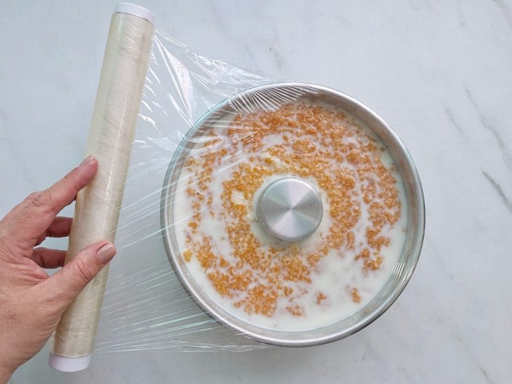 Bolo coberto e pronto para descansar na geladeira.