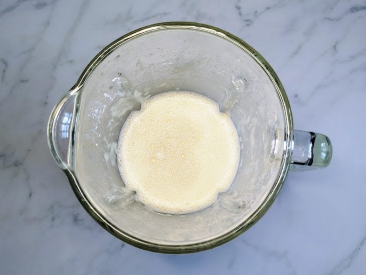 Um liquidificador com ovos, leite, polvilho doce, óleo e sal.