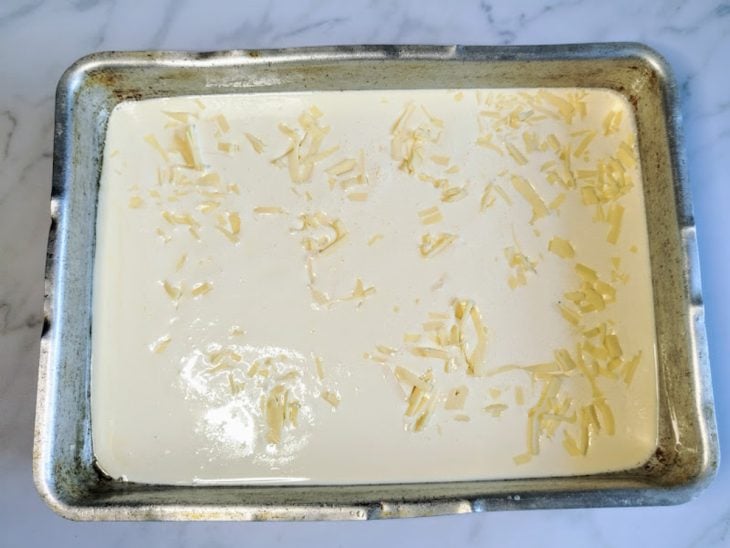 Uma forma com a massa do bolo e queijo.