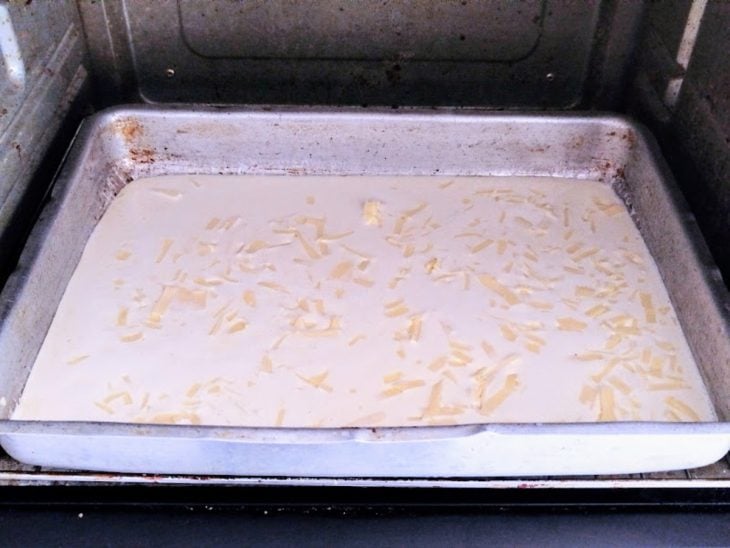 Uma forma com a massa do bolo no forno.