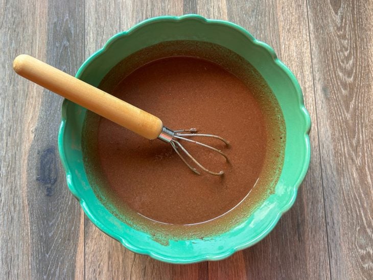 Tigela redonda com os ingrediente secos, leite de coco e vinagre misturados.