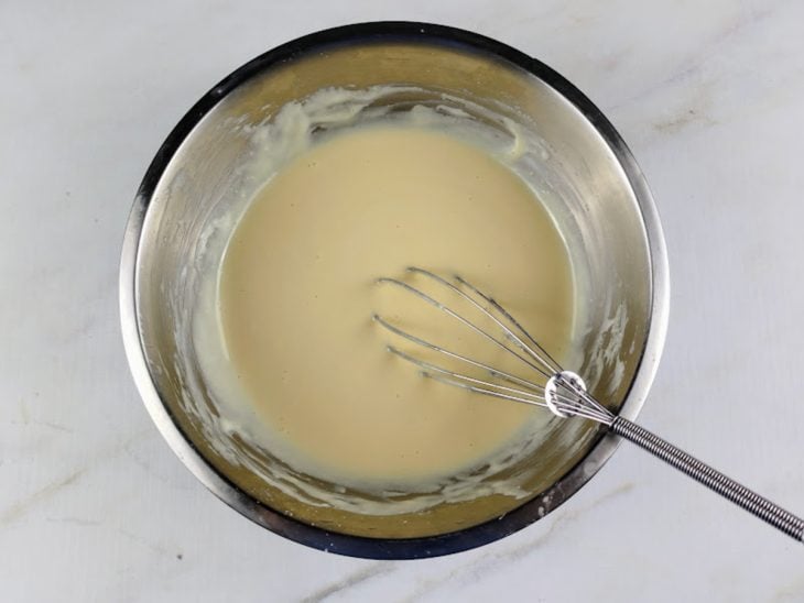 Uma tigela com a mistura de leite condensado, creme de leite e leite em pó.
