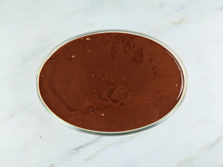 Travessa com bolo, creme branco e ganache.