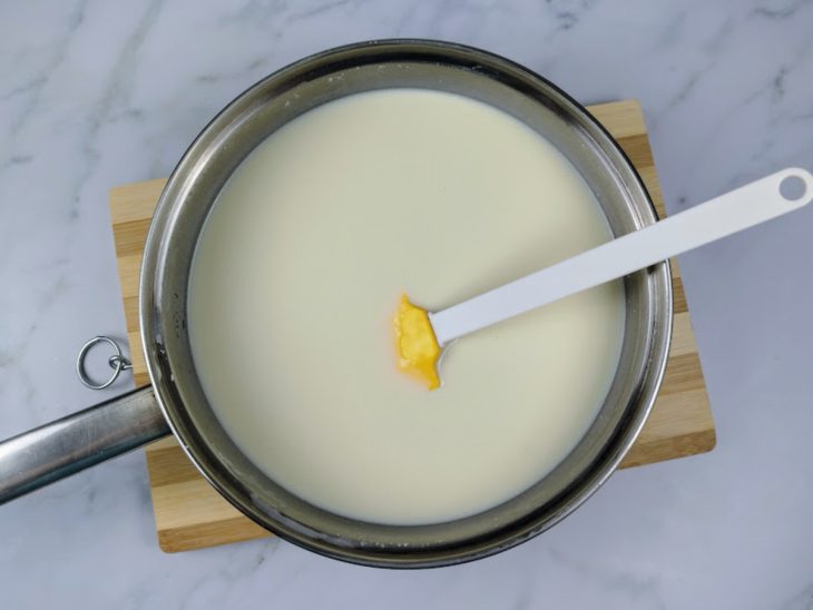 Uma panela com leite condensado, creme de leite, leite, leite em pó e amido de milho.