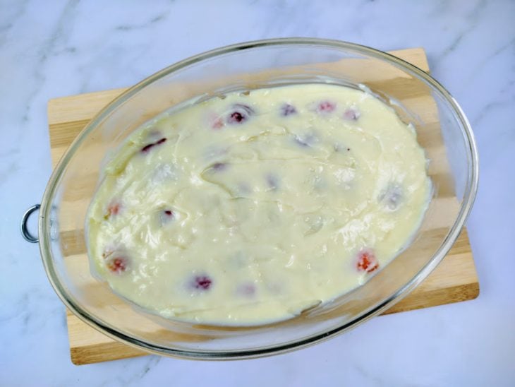 Uma travessa com uma camada de morango e outra de creme de leite Ninho.