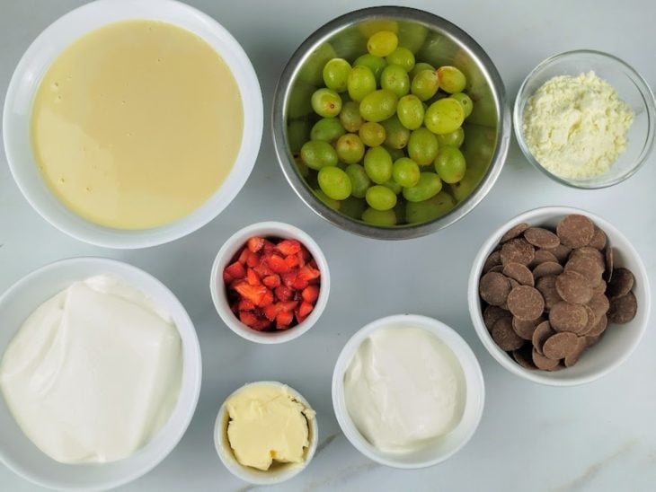 Ingredientes para o bombom de travessa de morango e uva reunidos na bancada.