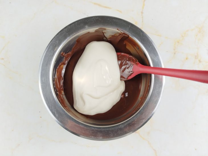 Creme de leite adicionado ao chocolate derretido.