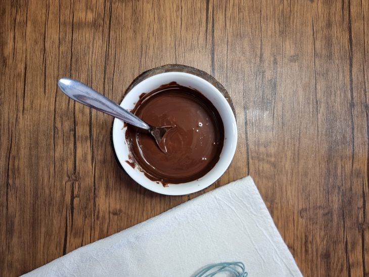 Chocolate derretido dentro de um potinho.