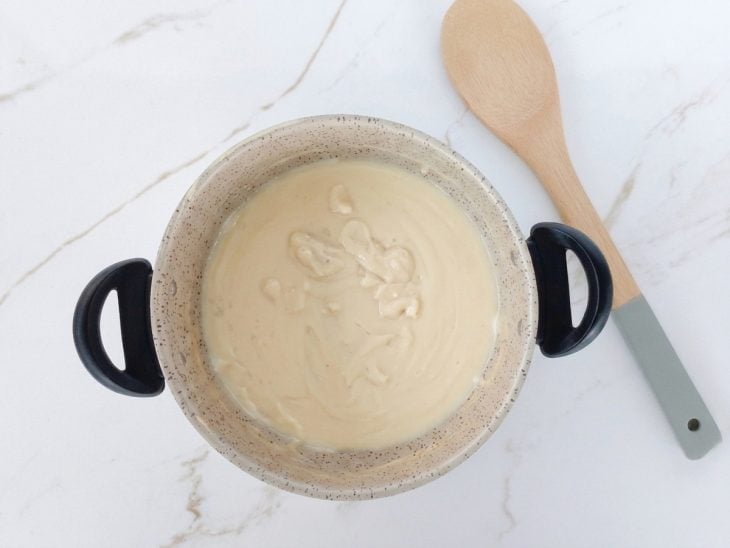 Creme sendo levado ao fogo e mexido até engrossar.