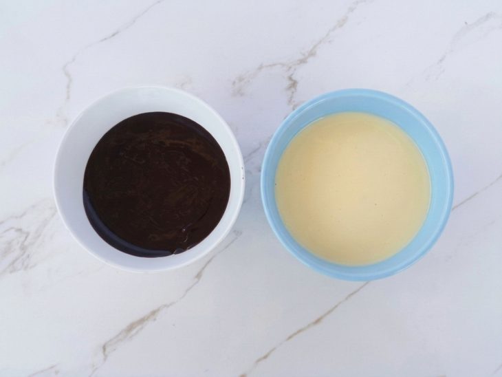 Chocolate sendo derretido com creme de leite em recipiente no micro-ondas.