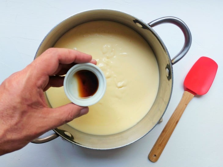 Uma panela contendo creme branco e essência de baunilha.