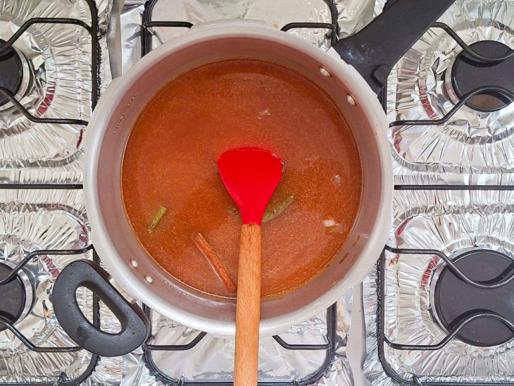 Caldo sendo formado com água, canela e temperos.