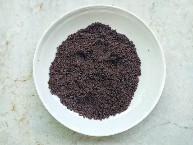 Biscoitos sem recheio sendo triturados até formar uma mistura fina e levemente granulada.