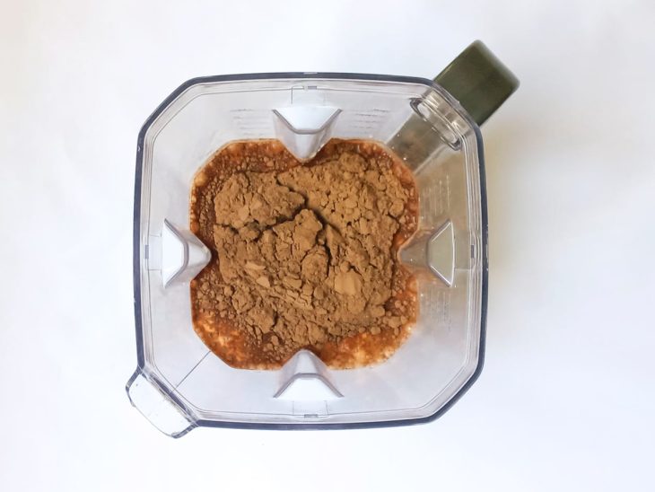 Um liquidificador com leite, leite condensado, creme de leite e chocolate em pó.