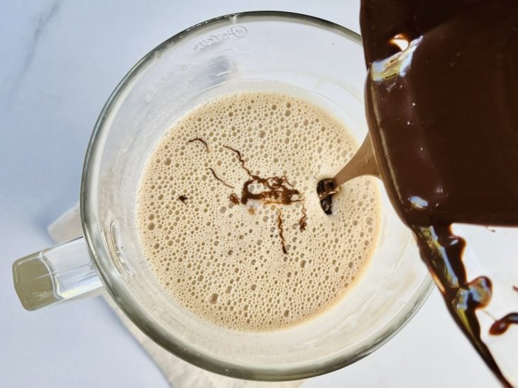 Chocolate derretido sendo adicionado no liquidificador com os outros ingredientes.