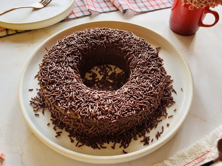 Um prato com brigadeirão de forno decorado com granulado.