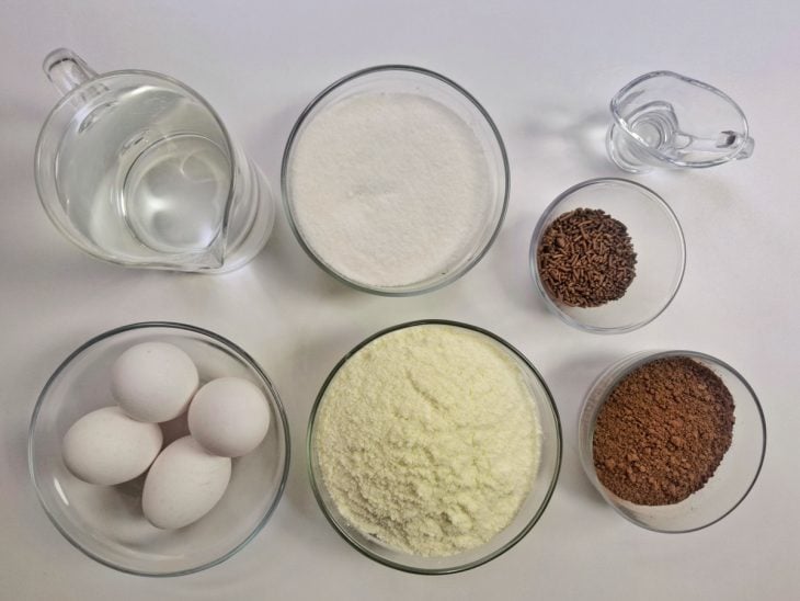 Ingredientes para a receita de brigadeirão simples reunidos em uma bancada.