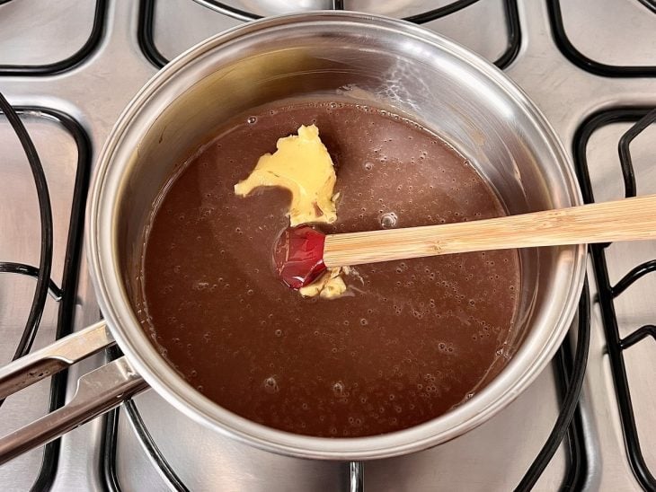 Uma panela contendo a mistura de leite condensado, chocolate em pó e manteiga.