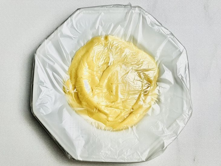 Prato com brigadeiro coberto com plástico filme.
