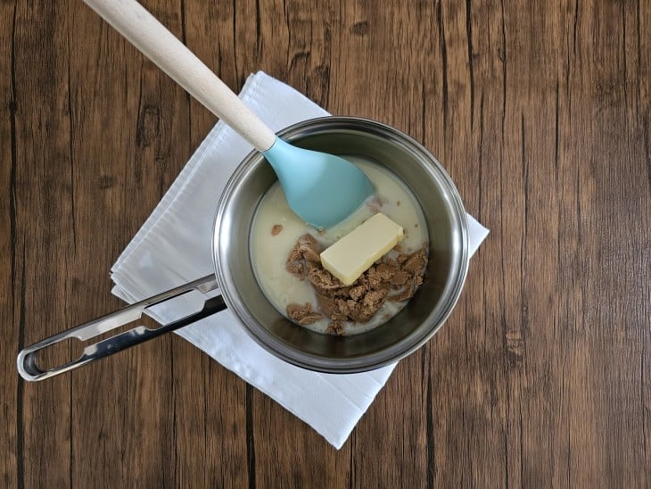 Uma panela com manteiga, leite condensado e pasta de amendoim.