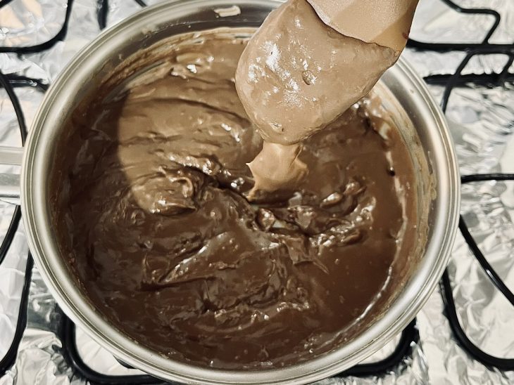 Brigadeiro na colher de pau, escorrendo mostrando o ponto ideal.