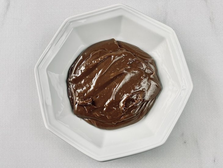 Brigadeiro colocado em um prato branco, para esfriar.