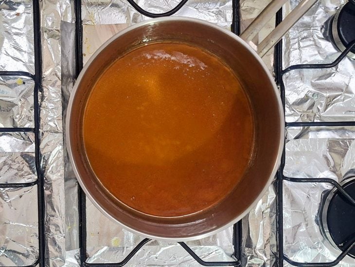 Açúcar derretido em panela em ponto de caramelo.