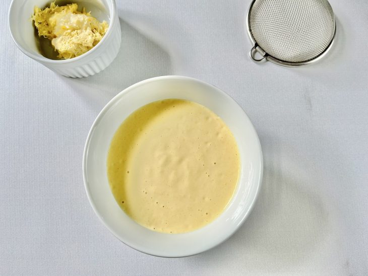 Creme de milho sendo peneirado para remover o bagaço.