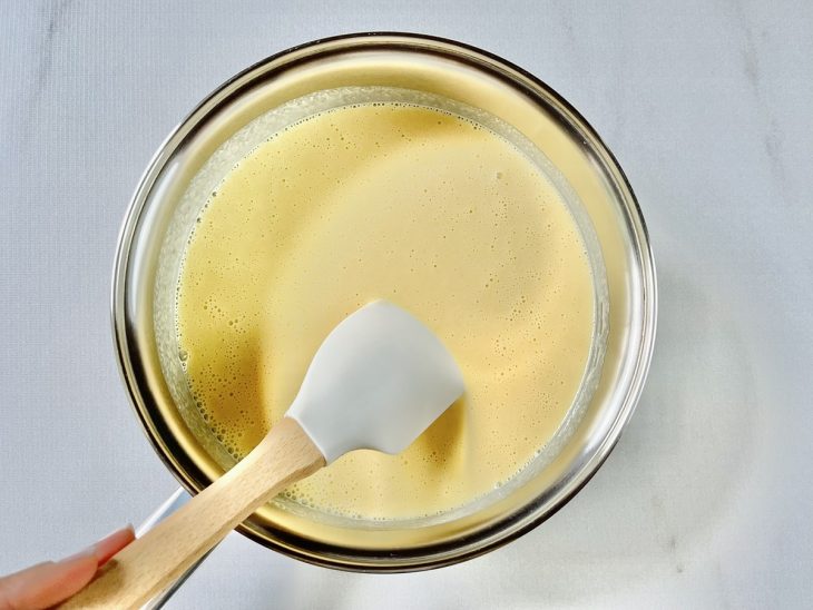 Mistura de milho e leite condensado sendo incorporada na panela.