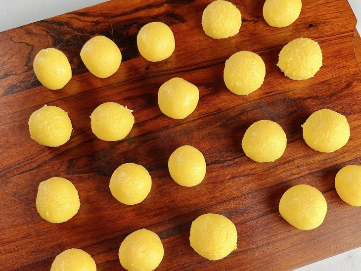 Brigadeiros modelados em bolinhas com as mãos untadas.