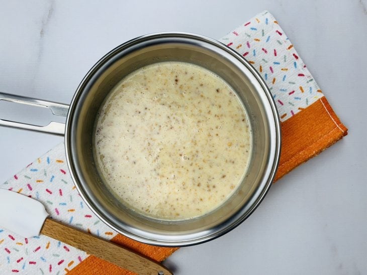 Uma panela contendo leite condensado, paçoca de amendoim triturada, creme de leite e manteiga.