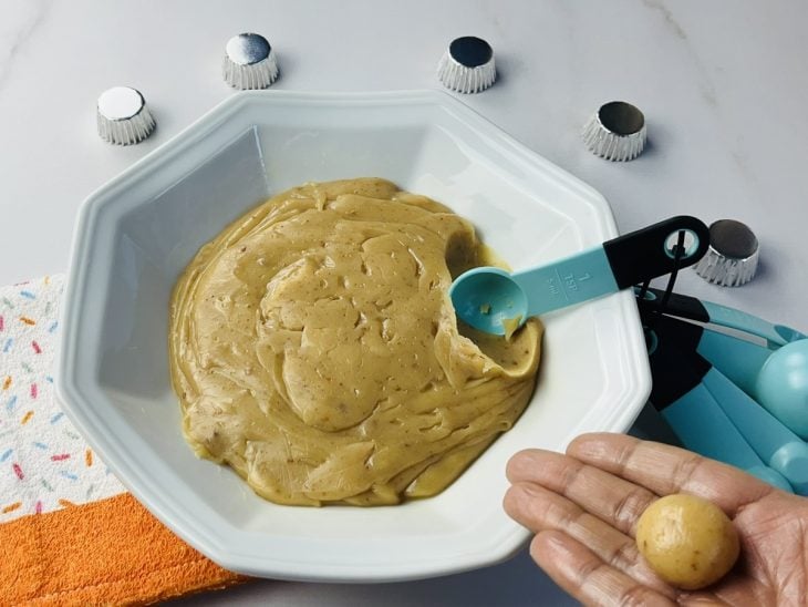 Um prato com massa de brigadeiro de paçoca sendo enrolado.