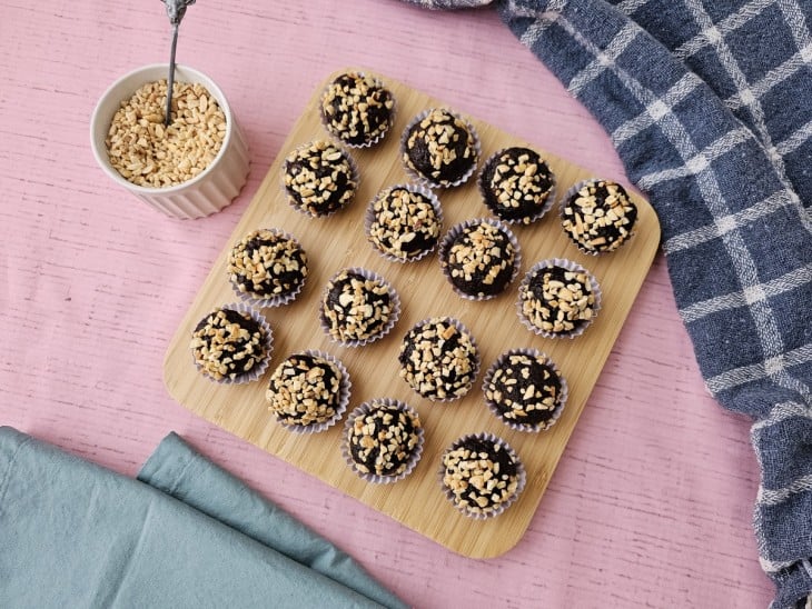 Uma tábua contendo brigadeiros fit de pasta de amendoim.