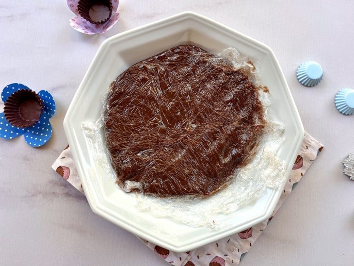 Brigadeiro gourmet embrulhado em plástico filme em um prato.