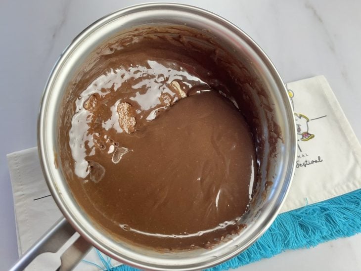 Uma panela contendo a mistura de leite condensado e chocolate em pó.