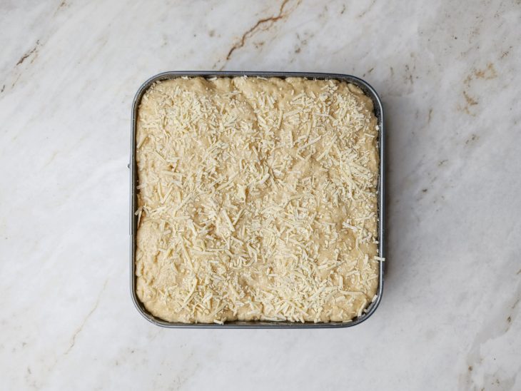 Margarina e queijo parmesão colocados na superfície.