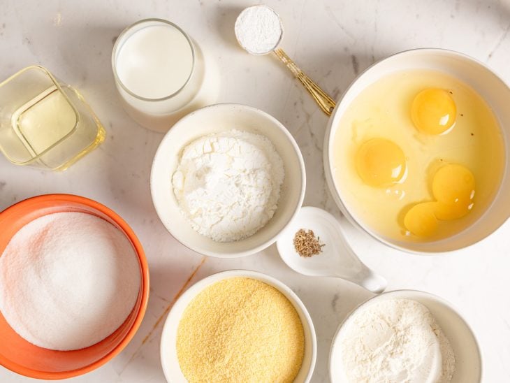 Ingredientes para a receita de broa de fubá de liquidificador reunidos em uma bancada.