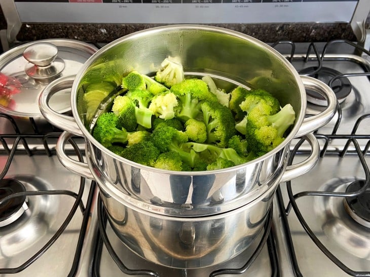 Uma panela com água e os floretes de brócolis.