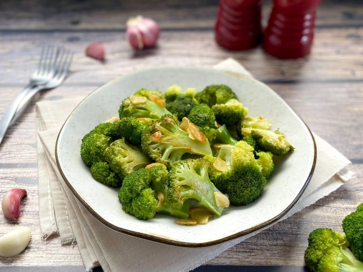Um prato contendo brócolis ao alho e óleo.