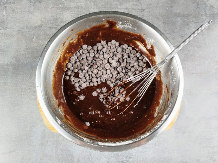 Farinha de trigo e gotas de chocolate incorporados na tigela.