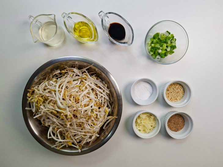 Ingredientes organizados sobre a bancada com alho e cebolinha picados.