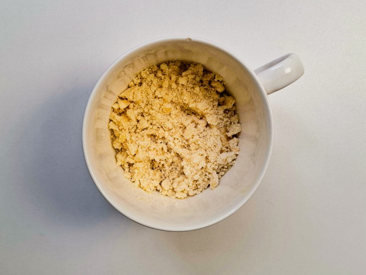 Margarina, farinha de trigo e açúcar colocados em uma caneca.