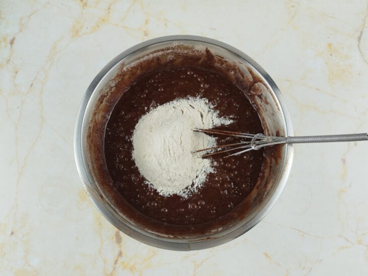 Massa recebendo cacau, açúcar e farinha até ficar homogênea.