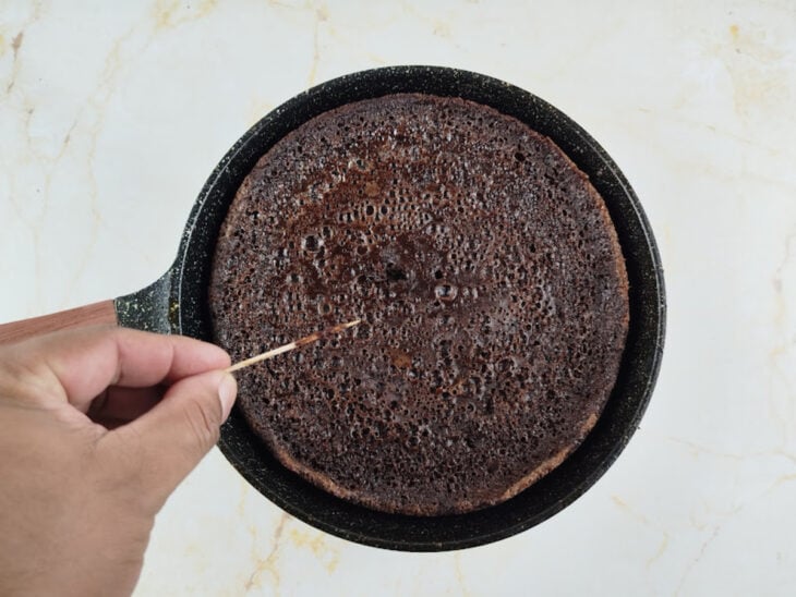 Teste do palito sendo realizado no centro do brownie já assado.