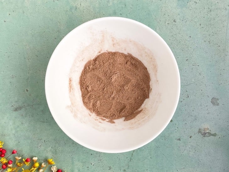 Um recipiente com a mistura de farinha, o açúcar e chocolate em pó.