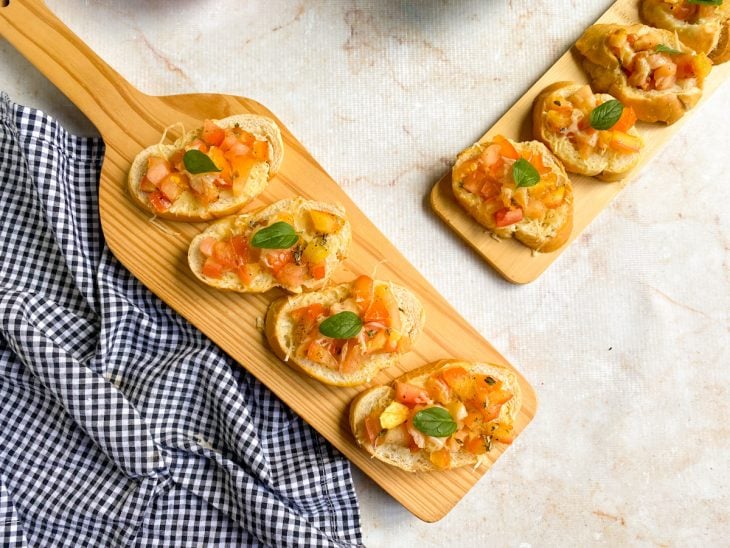 bruschettas finalizadas com manjericão fresco e prontas para servir.