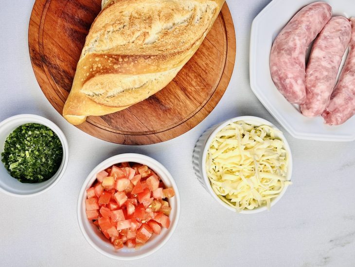 Ingredientes para preparo de bruschetta de linguiça organizados e separados.