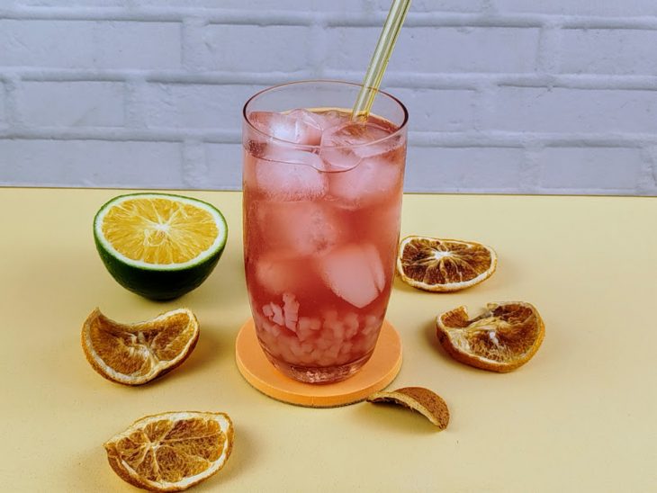 Bubble tea de chá laranja cor de rosa pronto para consumo em um copo de vidro.