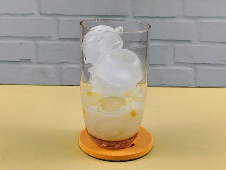 Copo de vidro com as bolinhas e gelo.