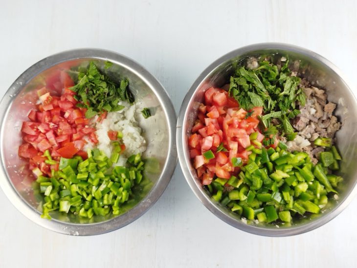 Cebolas, tomates, pimentões, alho e ervas picados na tigela.